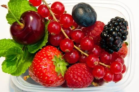 Berries in a plastic box on a white background Stock Photos