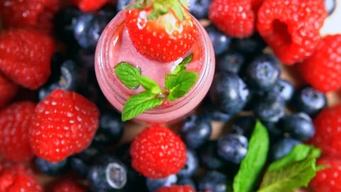 Berries Rotating. Assortment of Fresh berries blueberries and raspberries. Glass Stock-Footage 105345484
