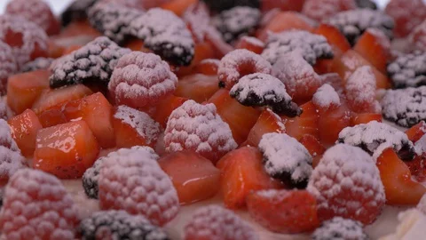 Berries on top of a Cake that is Rotating with prouder sugar on top. Cake Stock-Footage 127994187
