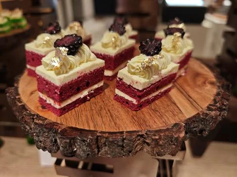 Berry Cream Layer Cake Squares on Rustic Wooden Stand at Dessert Buffet Stock-Fotos