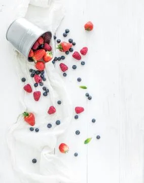 Berry frame with copy space on right. Metal bucket, strawberries, raspberries Stock Photos