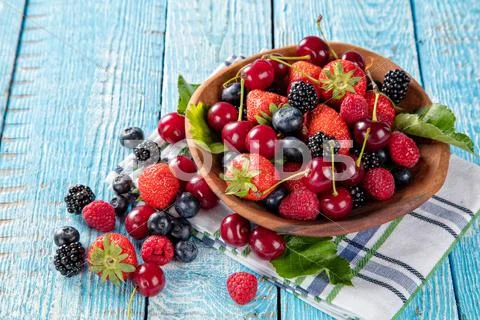 Berry fruit in saucer placed on old wooden planks Stock Photos
