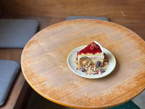 Berry Layer Cake Slice with Dried Citrus on Rustic Cafe Table Stock Photos