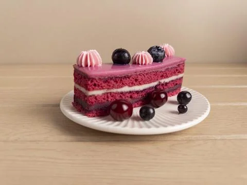 Berry Layer Cake Slice with Pink Icing and Fresh Berries on White Plate Stock Photos