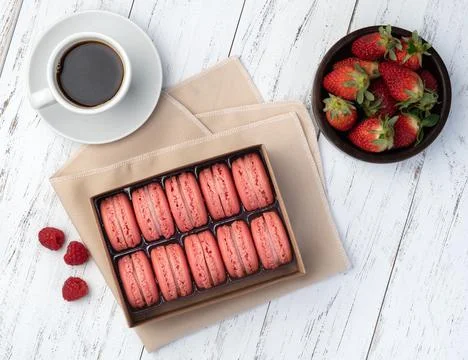 Berry macarons in a box with coffee over wooden table Fotos Stock