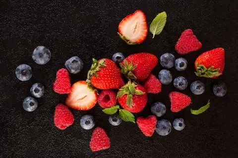 Berry mix on rustic black background. Stock Photos