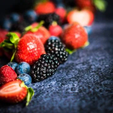 Berry mix on rustic black background Stock Photos