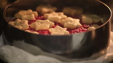 Berry pie with star-shaped shortcrust pastry on top baking in metal cake ring, Stock Footage 306303450