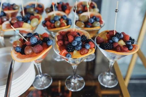 Berry-topped fruit cups sit in elegant glassware Stockfoto's