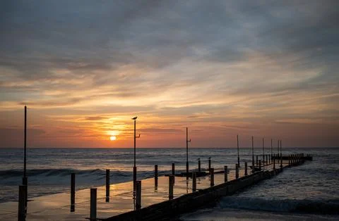 Berth at dawn, a bird sits on a column, seagulls by the sea Stock Photos