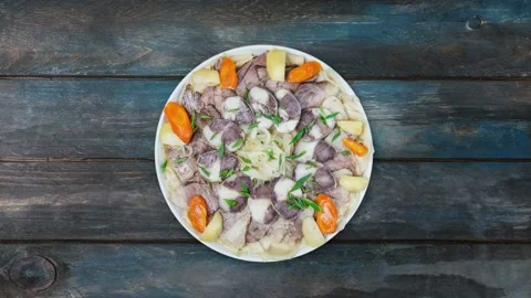 Beshbarmak dish rotates on a white plate. Noodles with lamb and onion close-up Stock Footage 128325054