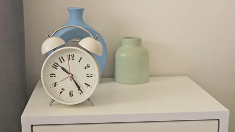 Beside bed, clocks stand on nightstand The steady tick tock of clocks fills room Stock Footage 274694802