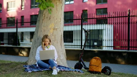 Beside of a big tree two students Afro American guy and blonde hair lady Stock Footage 138162359