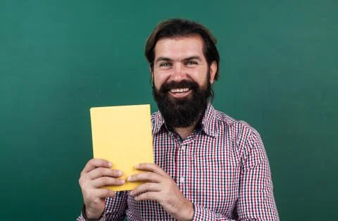 Best book ever. learning the subject. happy man with beard showing the book 写真素材
