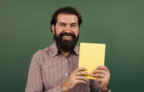 Best book ever. learning the subject. happy man with beard showing the book 写真素材