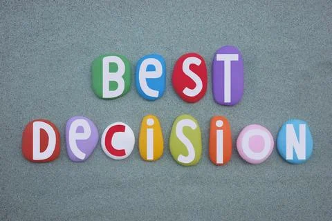 Best decision, slogan composed with multi colored stone letters over green sand Stock Photos