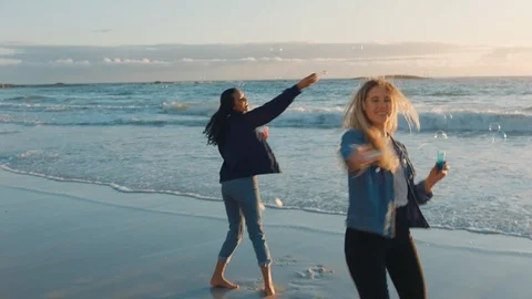 best friends blowing bubbles on beach at... | Stock Video | Pond5