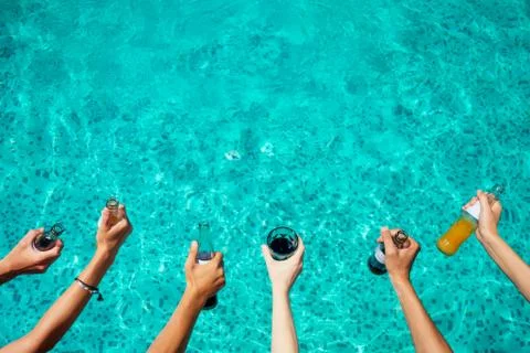 Best friends drinking lemonade while refreshing in the swimmingpool Stock Photos