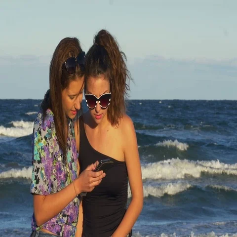 Best friends having fun on the beach with a smart phone Stock Footage 69699574