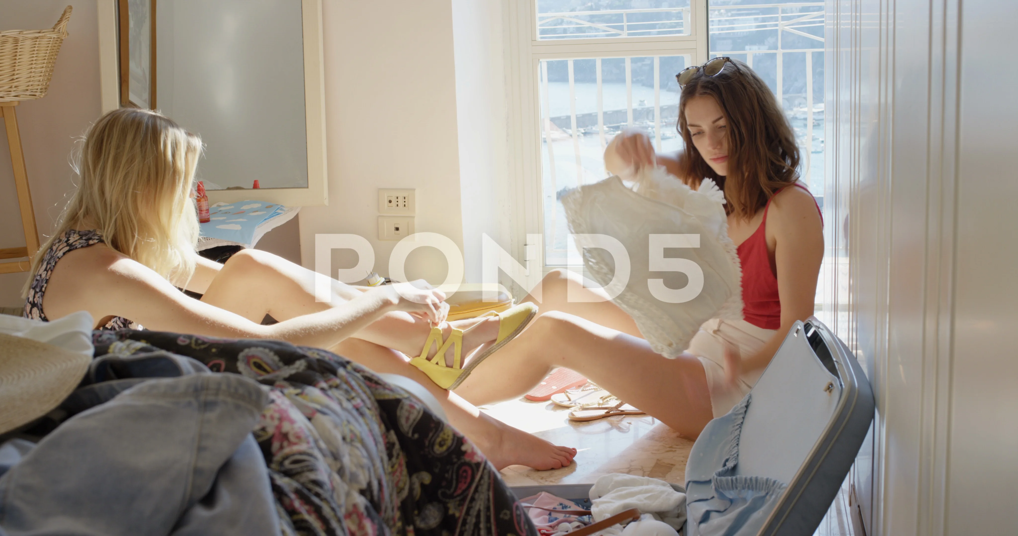 Best friends trying on clothes Tourist woman unpacking suitcase in hotel room pic