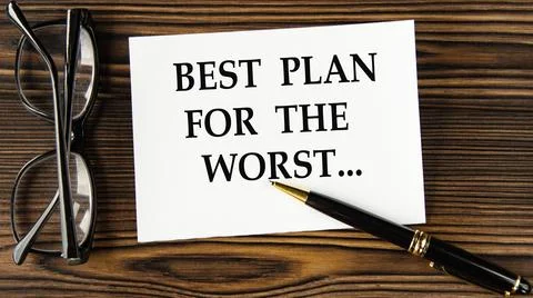 BEST PLAN FOR THE WORST - words on a white sheet on a brown wooden backgrou.. Stock Photos