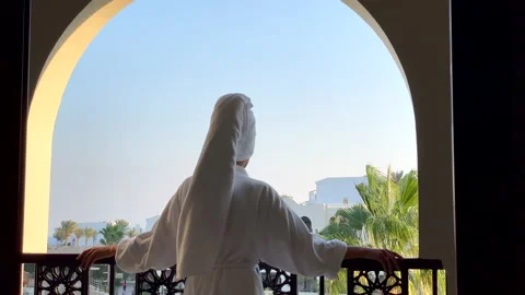 Best view. Rear view of young woman in bathrobe admiring the view from the hotel Stock Footage 151608516