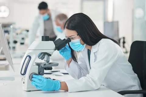 The best way forward is to keep at it. a young scientist using a microscope in a Stock Photos