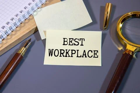 BEST WORKPLACE text on a notebook with keyboard, mouse and glasses. Stock Photos