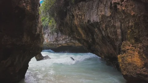 In between the rocky gorge with the turquoise ocean waves aerial footage Stock Footage 100653818