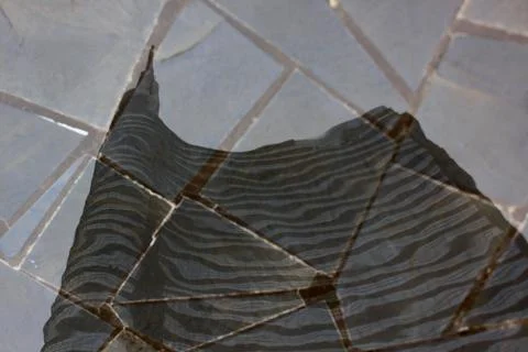 Between stone and sky. a skycraper reflection in a mosaic stone funtain. Stock Photos