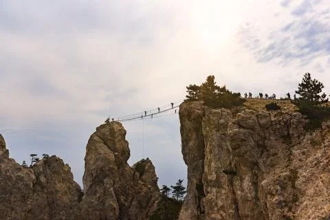 Between the stone teeth of mount AI-Petri stretched rope ladder. Silhouettes  Stock Photos