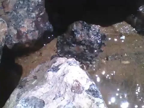 Between the stones of the beach, runs a small river of sea water, wonderful! Stock Footage 166428209