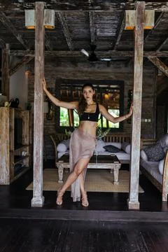 Between the two pillars holding hands behind them stands a girl in a long skirt Stock Photos