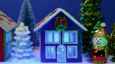 Between two snowmen there is a small Christmas village with colorful houses Stock Footage 302360119