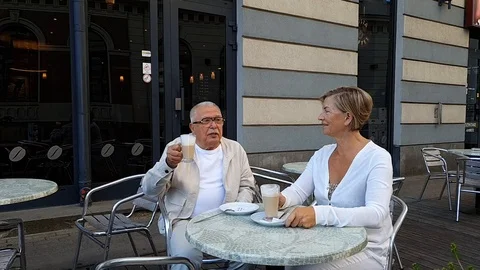 Beutiful elderly couple wearing white clothes sit at terrace Stock Footage 127182347