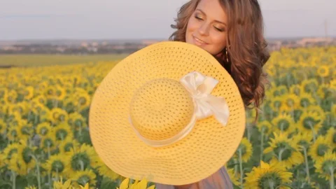 Beutiful girl cowgirl walk after work on filed sunflowers on sunset Stock Footage