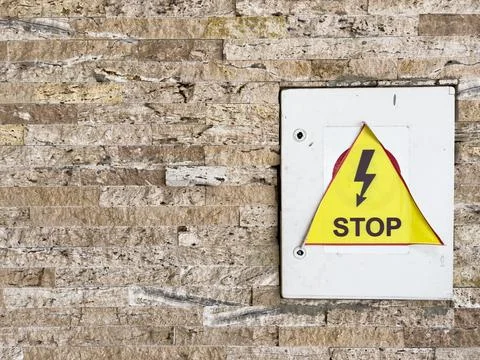 Beware of electrical hazards, dangerous electrical voltage on a yellow isolated Stock-Fotos