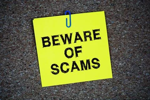 Beware of Scams text message on stick note on cork paper background Stock Photos