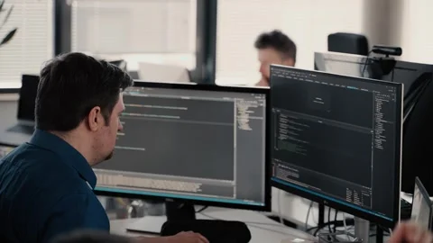 Bexbach, Germany - 06/17/2022: A man in front of two computer screen Stock Footage 263865998