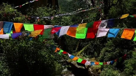 Bhutan prayer flags over a waterfall and mountains Stock Footage 69250383