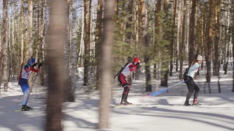 Biathletes Skiing through Forest during Ski Race Stock Footage 153070945