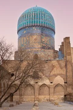 Bibi Khanym Mosque turquoise dome rising above brick walls at dusk in Samar.. Stock Photos