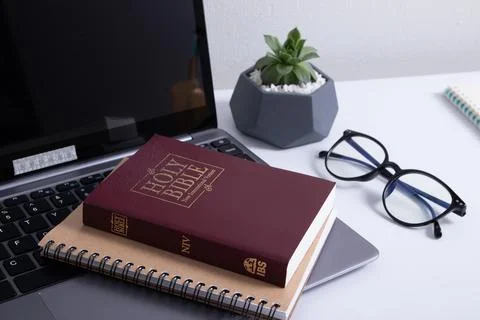 Bible and laptop on the work table with glasses. Holy Bible Study Online Stock-Fotos