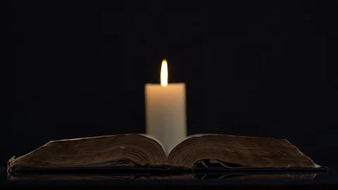 Bible and Wind Blowing Flame Of A Candle Stock-Footage 130165238