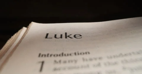 Bible book of Luke macro slide from title over page Stock Footage 257673516