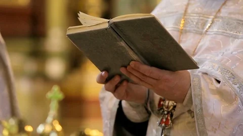 The Bible in the hands of the priest. Stock Footage 75073741