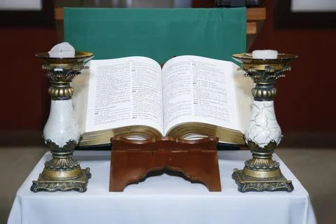 Bible open on altar with candlesticks Stock Photos
