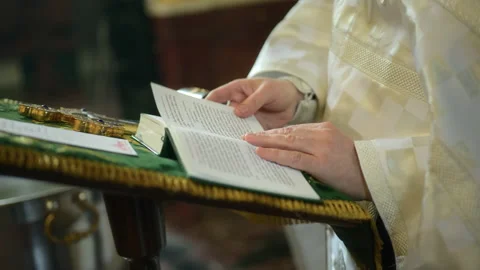 The Bible. The priest is leafing through a bible. The priest turns the pages of 스톡 동영상 243097817