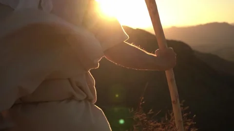 A Bible prophet on a mountain top holding his staff at sunset Stock Footage 255316475