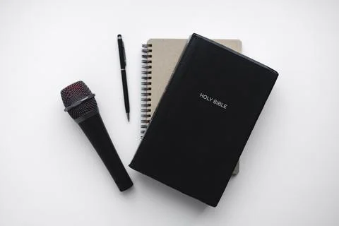 Bible study setup with microphone, notebook and pen isolated on white. Foto stock